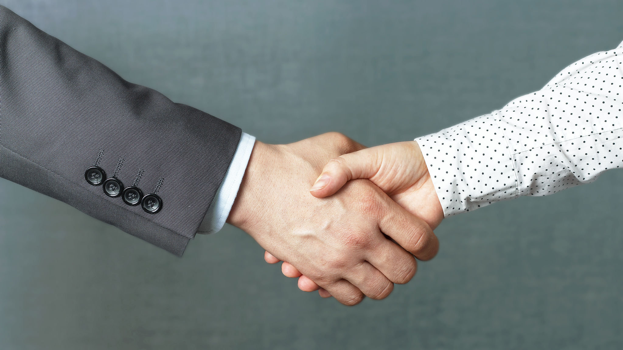 Handshake of man and woman in business clothes, close up front view